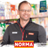 Lächelnder Mann in Norma-Uniform mit "Top Arbeitgeber Mittelstand 2024" Siegel und Norma-Logo.