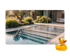 Moderner Pool mit Treppe, umgeben von Pflanzen und einer Terrasse mit Möbeln.