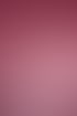 Lachende Frau mit kurzen schwarzen Haaren und Tätowierungen trägt einen rosa Strickpullover vor pinkem Hintergrund.