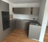 Moderne U-förmige Küche in mattgrau mit Holzboden und Einbaubackofen.