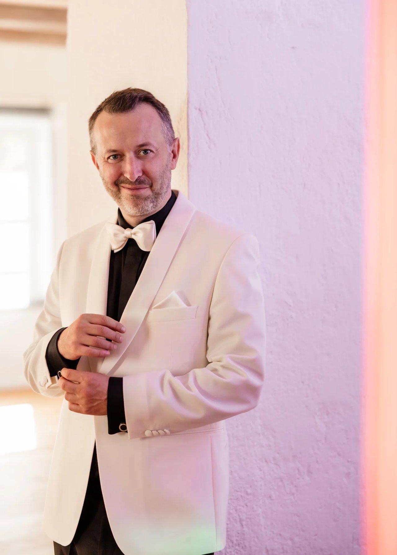 Portrait von Hochzeits-DJ Michael Newell im weißen Dinnerjacket mit Fliege