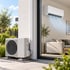 Eine moderne Split-Klimaanlage mit Außengerät im Garten und Innengerät an einer Wohnzimmerwand.