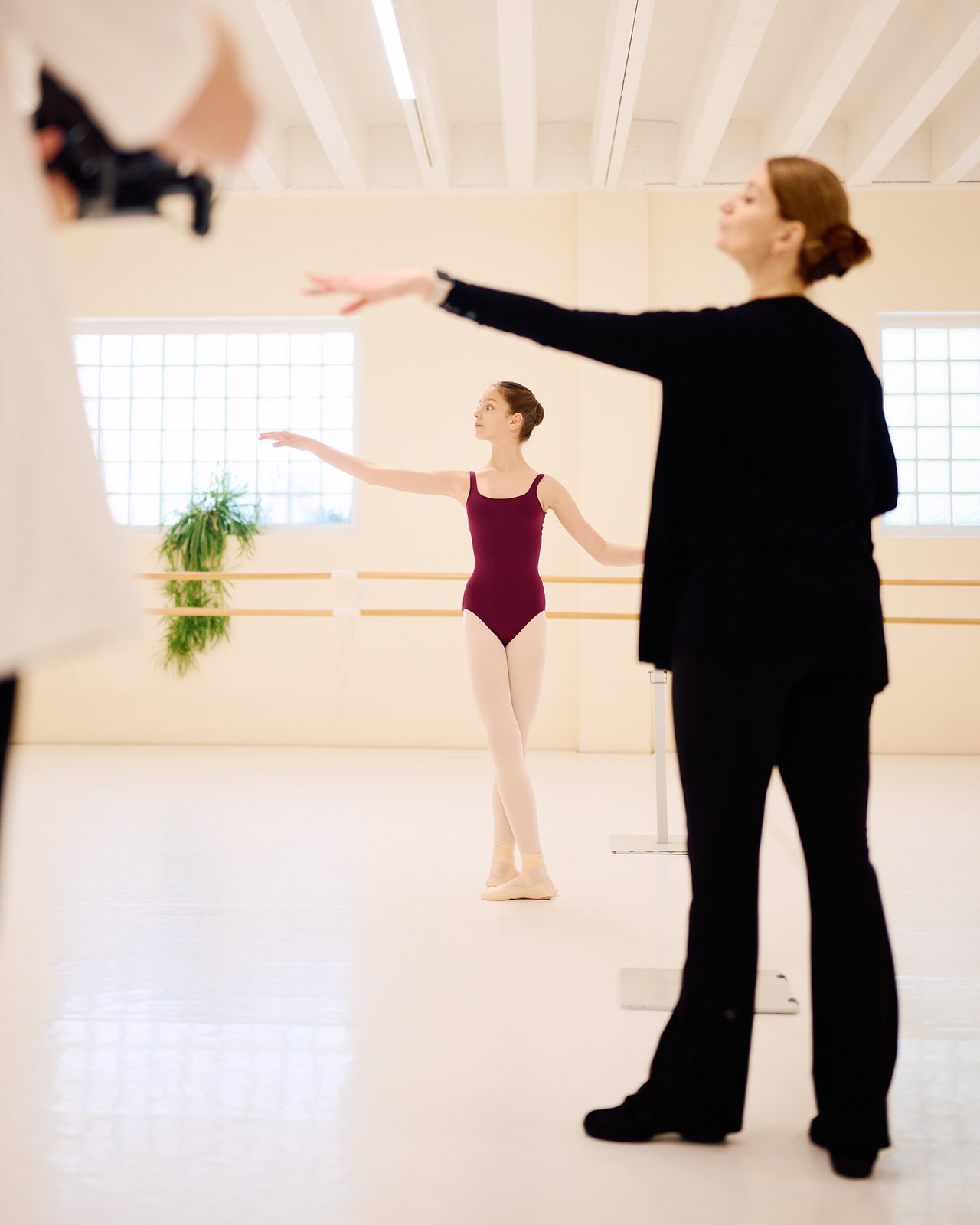 Nina demonstrates a movement while the dancer watches and follows.