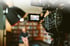 Professionelle Videokamera filmt eine unscharfe Person vor einem Bücherregal, mit einem Softbox-Licht.