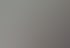 Eine Geschäftsfrau im braunen Blazer spricht in einem Meeting vor einem Whiteboard mit Kollegen.