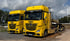 Zwei gelbe ADAC Lkw mit HESS-Beschriftung und Mercedes-Benz Sternen stehen auf einem Schotterparkplatz.