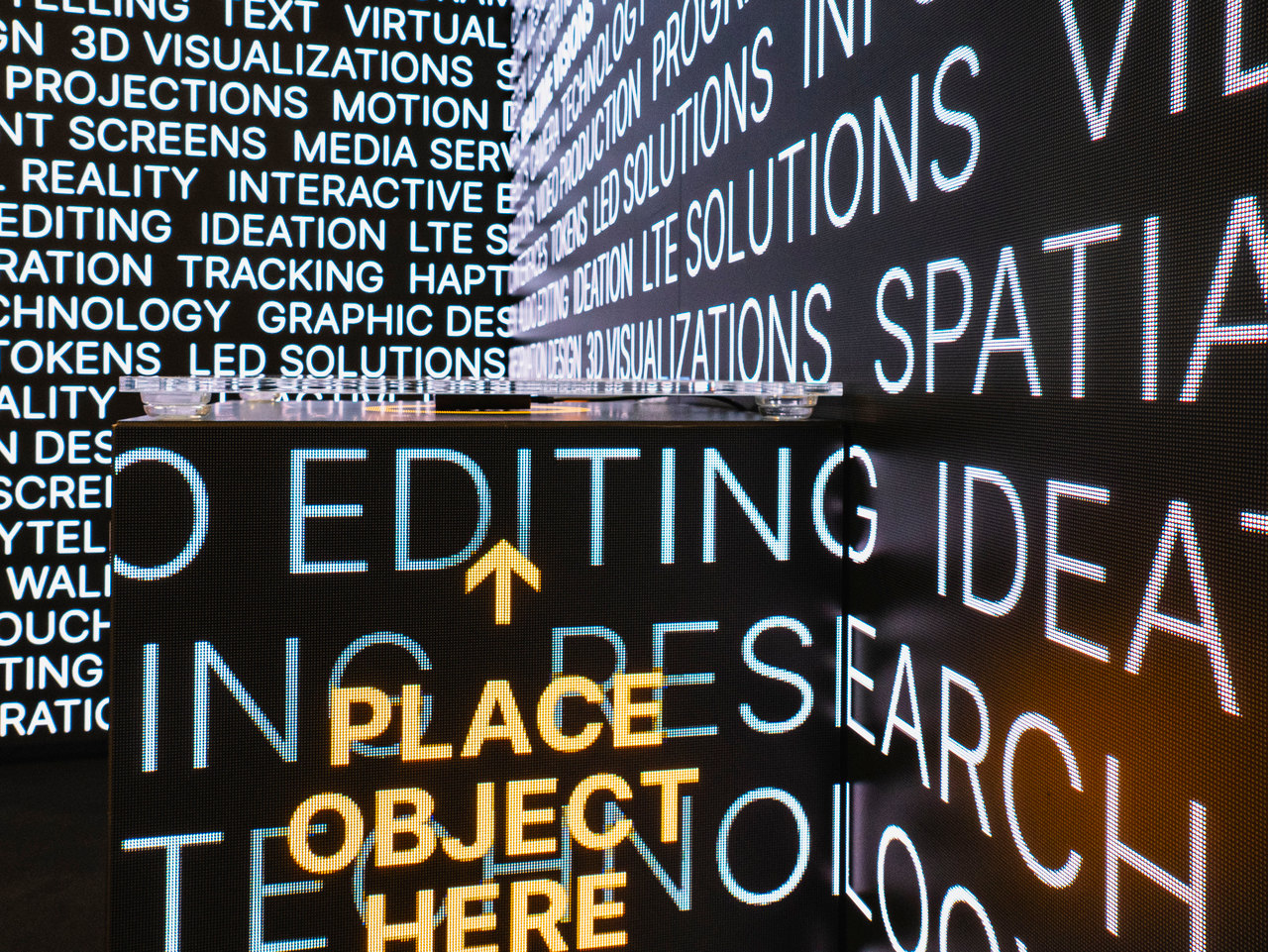 Interaktive Typografie-LED-Wall: Begriffe wie 3D Visualizations, LED Solutions, Spatial Storytelling und Ideation flücken durch das Pixelraster – eine der auffallendsten Installationen der Messe