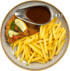 Ein Schnitzel mit Pommes Frites, Soße in Sauciere, Zitronenspalte, Petersilie, Gurken- und Tomatenscheiben auf einem Teller.