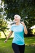 A happy woman with short hair walking in a park.