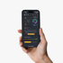 Eine Hand hält ein Smartphone mit der Solar-Log App, die Energieflüsse, PV-Performance und Verbrauchsdaten anzeigt.