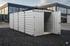 Silberner Container mit offener Tür auf Schotter vor einem modernen Gebäude.