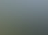 Mobilfunkantenne auf einem Mast über einer Autobahn, umgeben von grünen Feldern und einem Rapsfeld unter blauem Himmel.