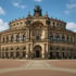 Das Semperoper-Gebäude in Dresden mit Kuppel, Säulen und Statuen unter blauem Himmel.