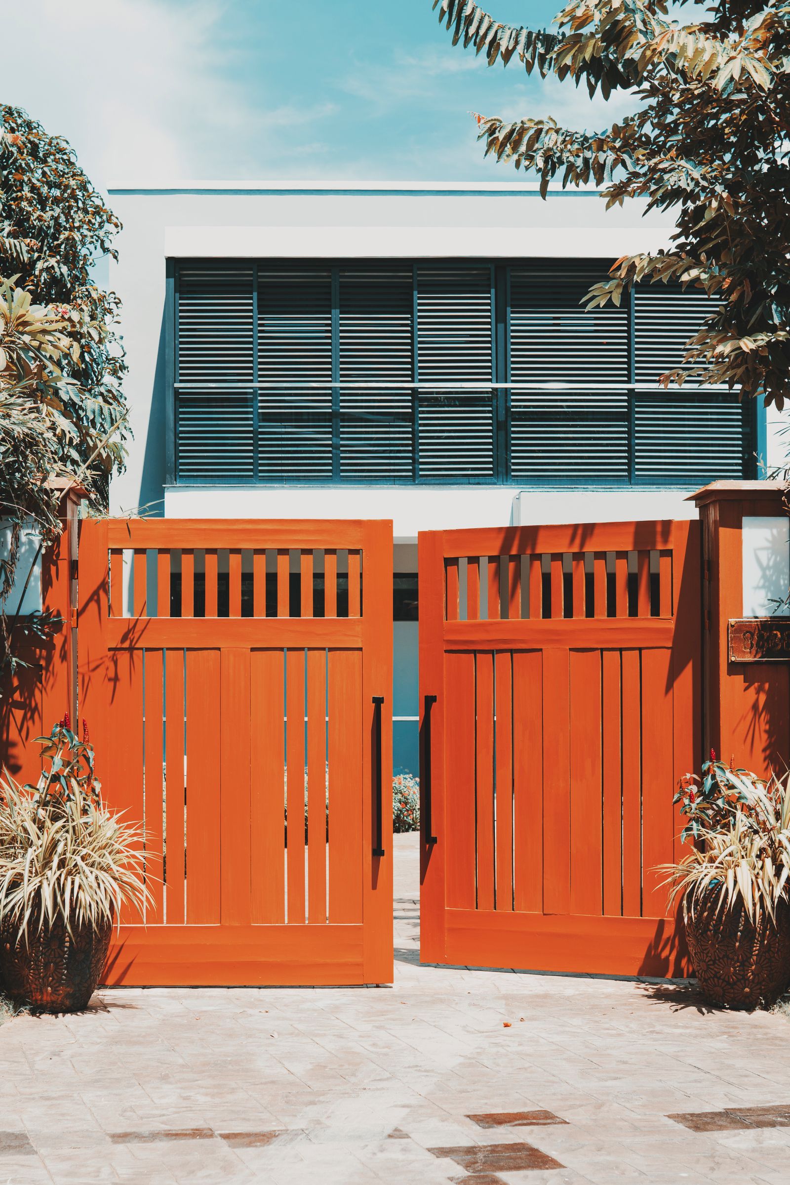 Wooden driveway gates open to a home