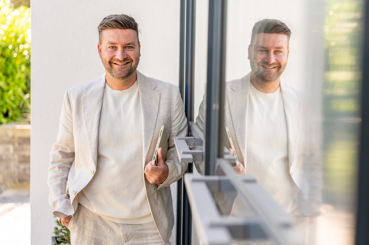 Immobilienmakler Florian Alexander im Gespräch mit Eigentümern beim Verkauf ihrer Immobilie