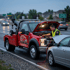 Towing Sandy jump start service providing roadside battery assistance to a stalled vehicle during rainy evening conditions.