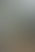 Ein Mann fährt einen gelben Kompaktlader mit einer Palette grauer Pflastersteine auf einer Baustelle.