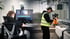 Ein Editor beim Videoschnitt am Monitor und ein Kameramann mit Gimbal bei Filmaufnahmen auf einer Baustelle.