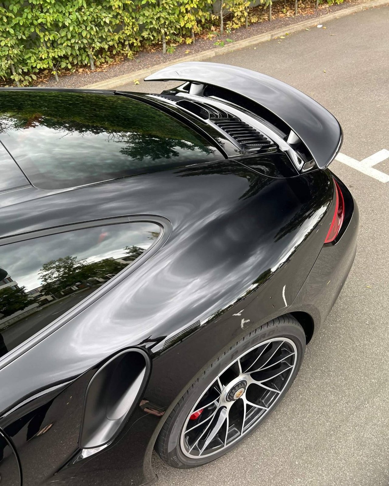 Schwarzer Porsche 911 – Heckpartie mit ausgefahrenem Spoiler