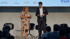 Eine Frau und ein Mann stehen auf einer Bühne vor Publikum, Logos von e.discom, O2, PYUR und Vodafone im Hintergrund.