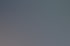 Eine Person tippt an einem Schreibtisch auf einer schwarzen Tastatur neben einem Notizblock mit Stift.