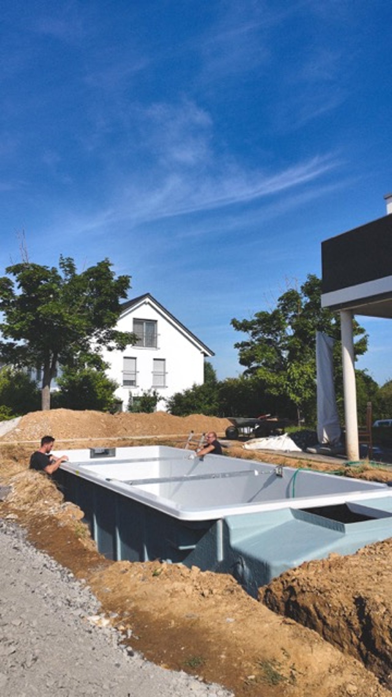 POOL+HOME Mitarbeiter beim Beckeneinbau im ausgehobenen Garten
