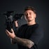 Graue Sony-Filmkamera mit großem Objektiv auf einem schwarzen DJI RS 2 Gimbal-Stabilisator mit Stativ.