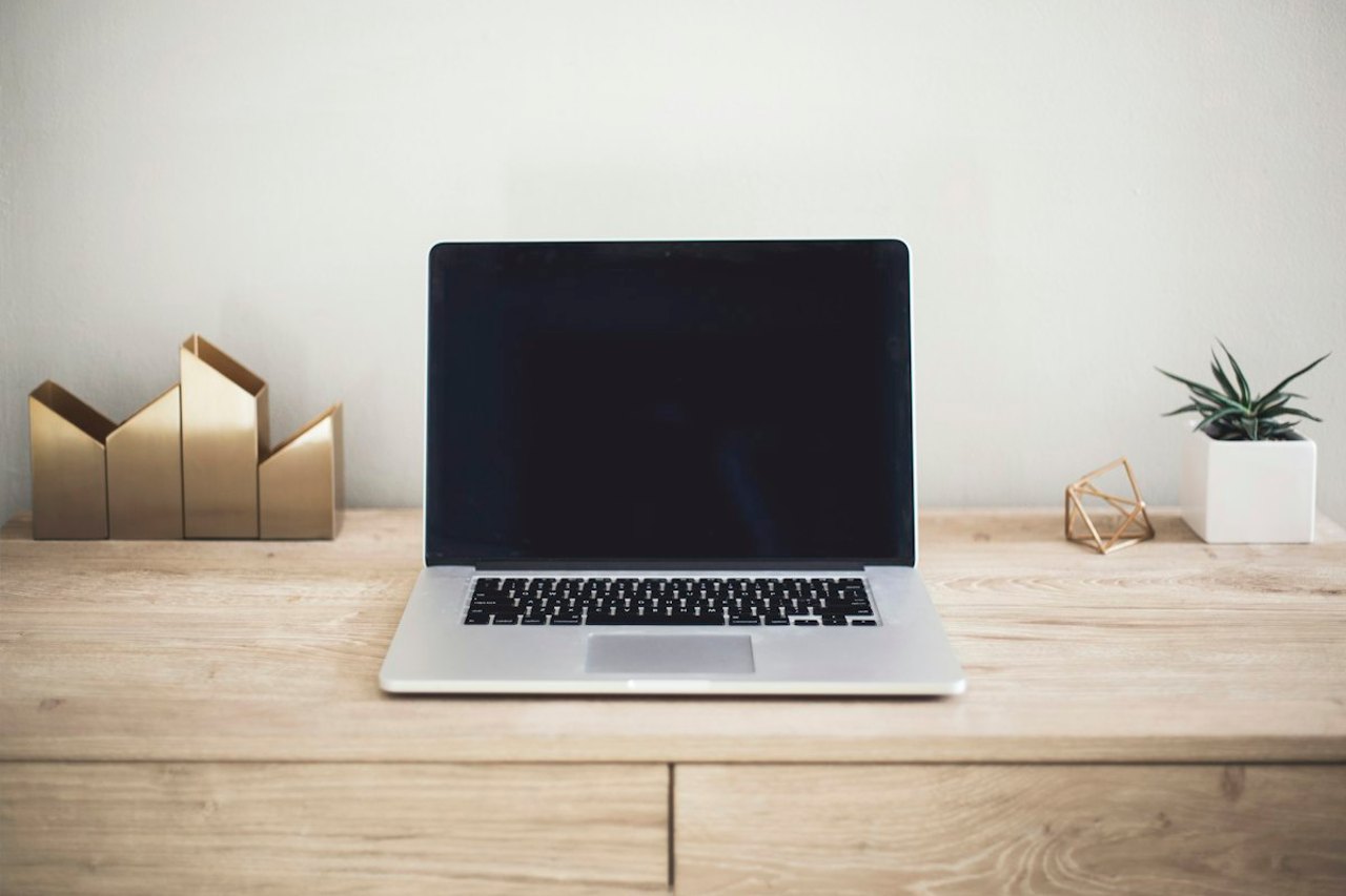 Aufgeklappter Laptop auf einem Holztisch