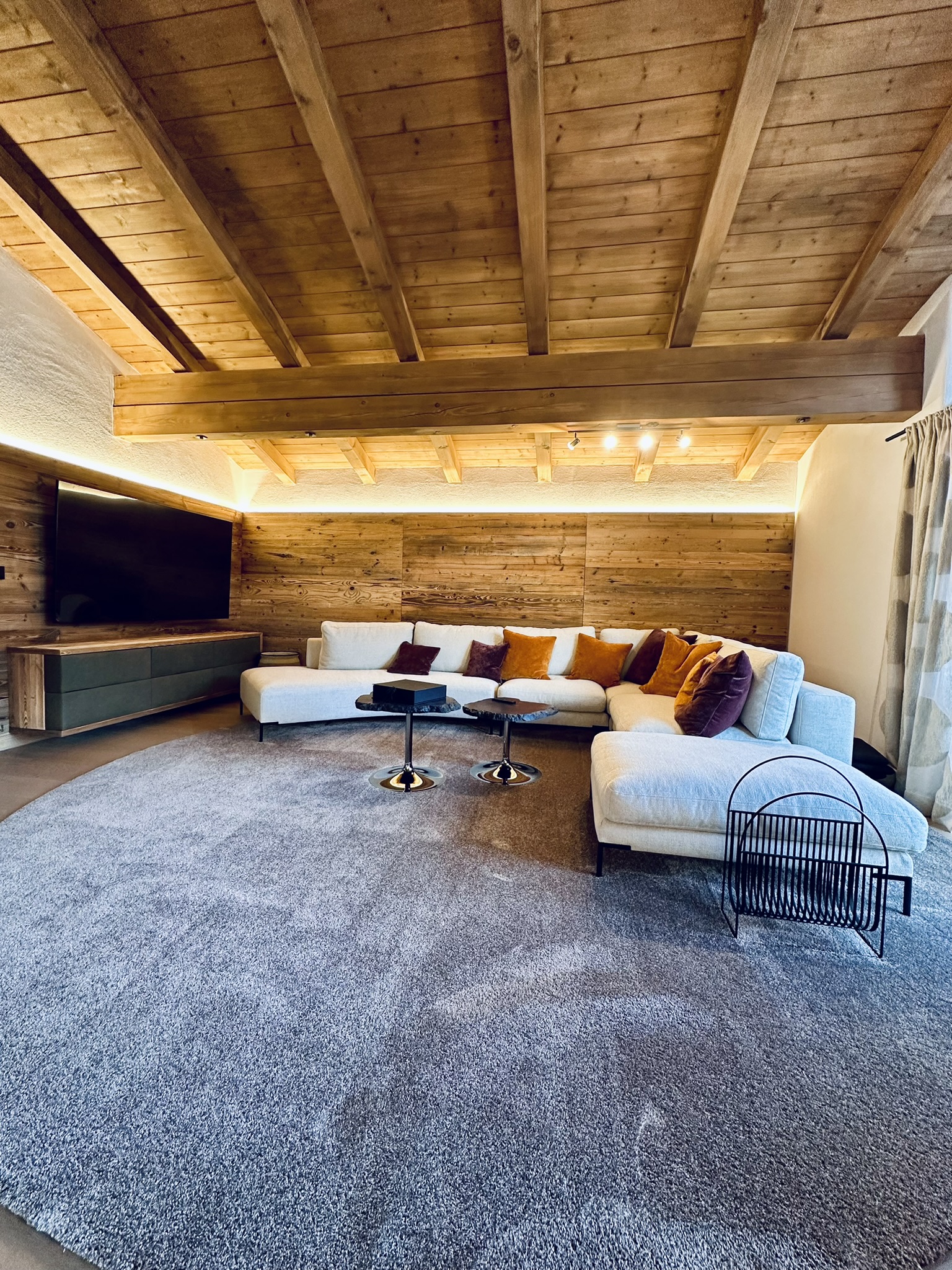 Wohnraum mit Holzdecke und großer Couch
