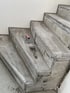 Betontreppe im Bau mit Fliesenlegerwerkzeugen, verputzt und mit Metallschienen für Fliesen versehen.