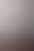 Modernes Schlafzimmer mit weißem Boxspringbett, Parkettboden, dunklem Nachttisch und einem Wandbild über dem Kopfteil.