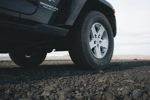 Four-wheel-drive SUV wheel on gravel, illustrating when an AWD car needs a flatbed tow in Corona, CA