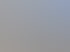 Modernes, gläsernes Bürogebäude mit schrägen Wänden und blau-weiß gestreiftem Boden.