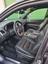Innenansicht eines Jeep-Fahrzeugs mit schwarzem Lederinterieur, Lenkrad, Armaturenbrett und Schalthebel.