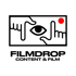 Schwarz-weißes Logo: Hände formen einen Rahmen um ein Auge; roter Punkt oben rechts; Text "FILMDROP CONTENT & FILM".