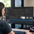 Frau betrachtet am Computer eine Sicherheitssoftware mit Grundriss, Videoüberwachung und Personalausweis-Daten.
