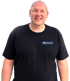 Porträt von Jürg Wingeier im schwarzen T-Shirt mit Firmenlogo Wingeier Trubschachen vor schwarzem Hintergrund.