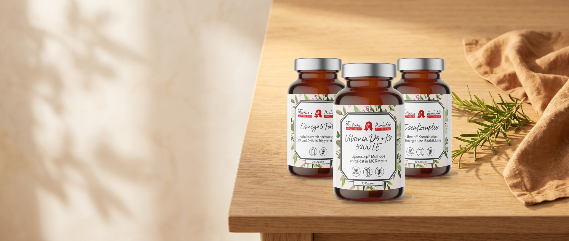 Omega 3 Forte, Vitamin D3 + K2 3200 I.E. und Eisen Komplex der Classic-Linie auf einem Eichentisch mit Rosmarin
