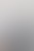 Ein lächelnder Mann im blauen Anzug mit schwarzer Fliege gestikuliert mit den Händen vor einem hellen Fenster.