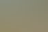 Zwei Personen gehen am Rand eines Sandplatzes vorbei, wo mehrere Gruppen Beachvolleyball spielen.