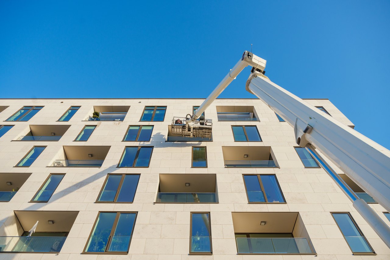 Fensterputzer Berlin beim reinigen der Glasflächen an der Hausfassade eines Objektes einer Hausverwaltung