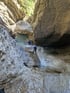Zwei Personen seilen sich einen Wasserfall in einer felsigen Schlucht ab.