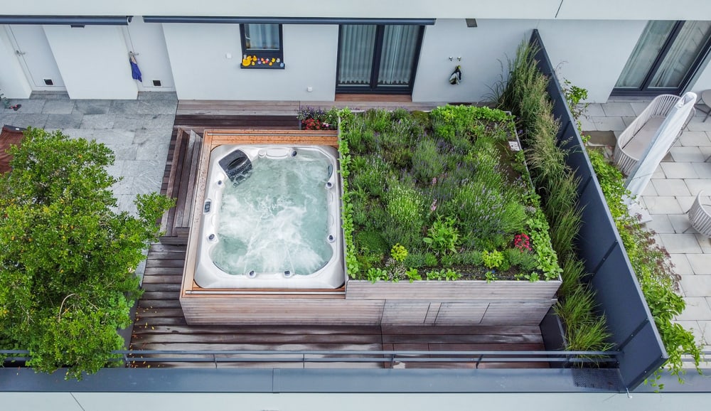 Whirlpool auf einer Dachterrasse von oben, daneben ein bepflanztes Hochbeet
