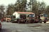 Drei MAN-Lkw mit Absetzcontainern stehen vor einem Werkstattgebäude am Waldrand.