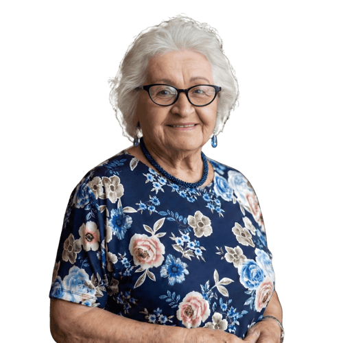 Smiling older woman with grey hair, glasses and a blue floral dress against a green background.