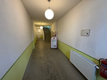 Hausflur mit grün-weißer Wandgestaltung und Blick zum Treppenhaus