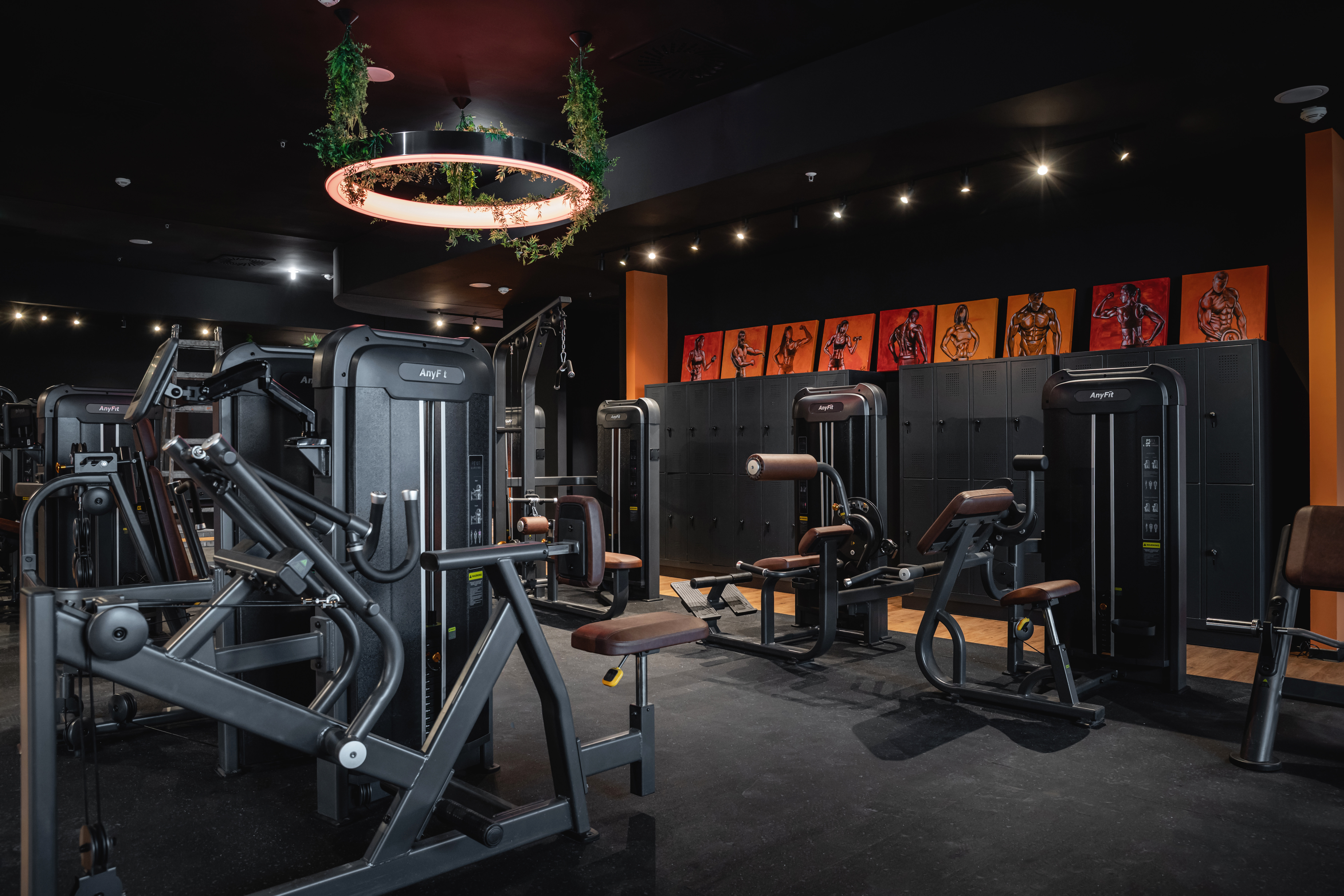 GYMPOD Studio mit schwarzen Trainingsgeräten und orangen Akzenten