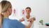 Therapist guides a patient's arm exercises at a pain control clinic.