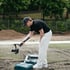 Ein Mann mit schwarzer Kappe filmt im Freien mit einer Kamera auf einem Gimbal-Stabilisator bodennahe Aufnahmen.