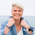 Iris Becker von Meerwege Coaching, dein Stärkenbuddy lächelnd mit Hände am Kragen